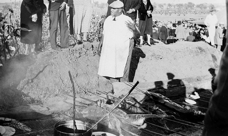A local pitmaster tends a barbecue pit dug into the ground. JACKSON COUNTY (MISSOURI) HISTORICAL SOCIETY ARCHIVES