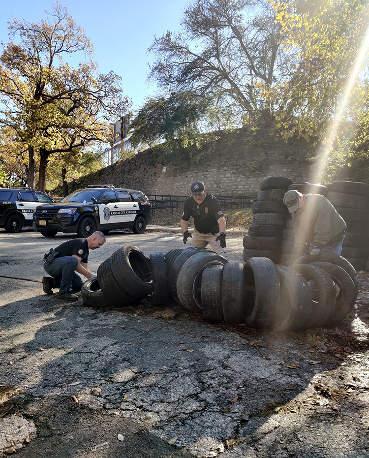 KCK police officers assist with a discarded tire cleanup at the arch. ROSEDALE DEVELOPMENT ASSOCIATION