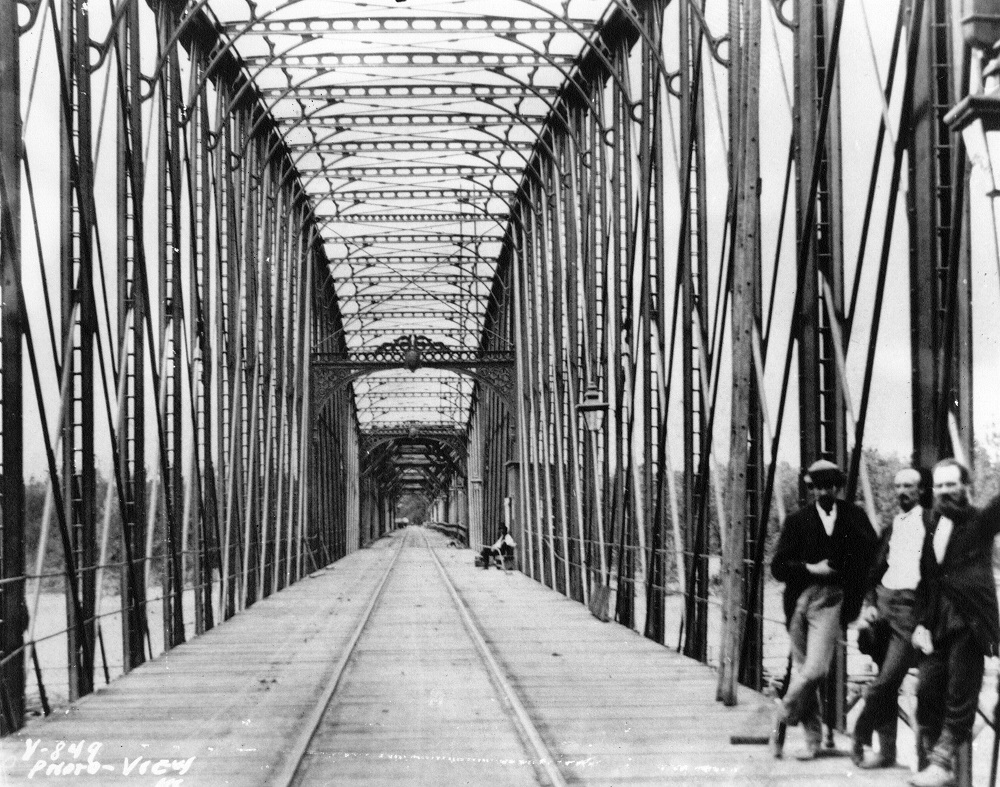 Octave Chanute (middle) standing atop the wooden planks on the completed bridge, 1869.